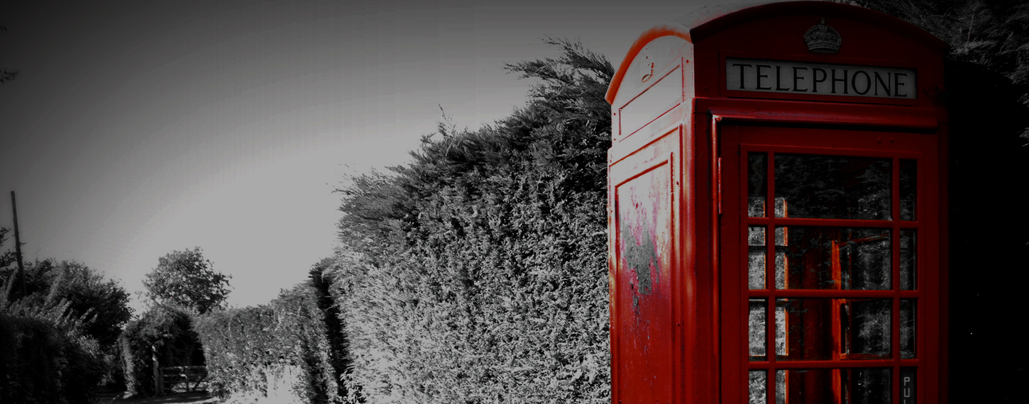 Red Telephone Boxes next to a wall